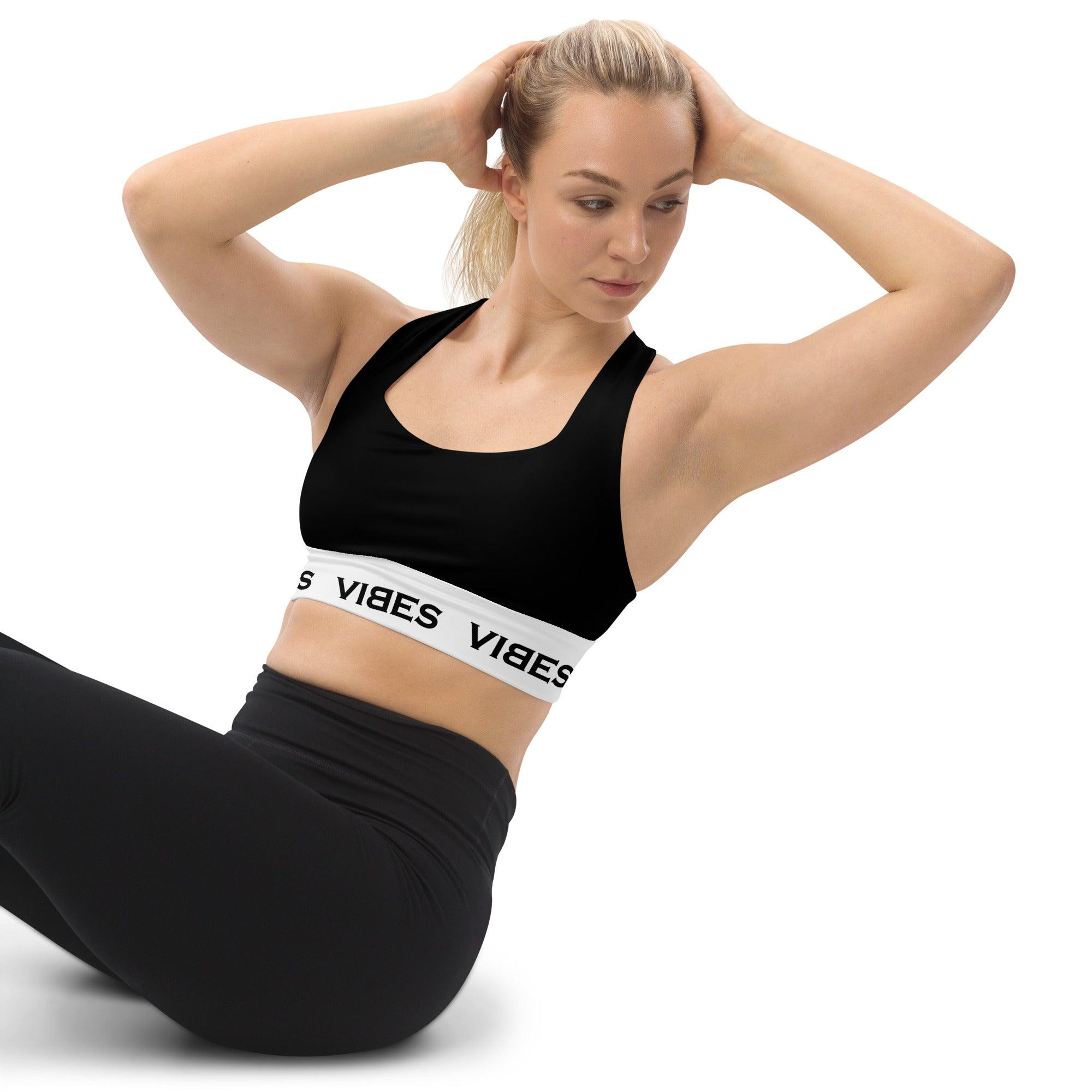 Frau in schwarzem VIBES Sport-BH und Leggings beim Workout vor weißem Hintergrund