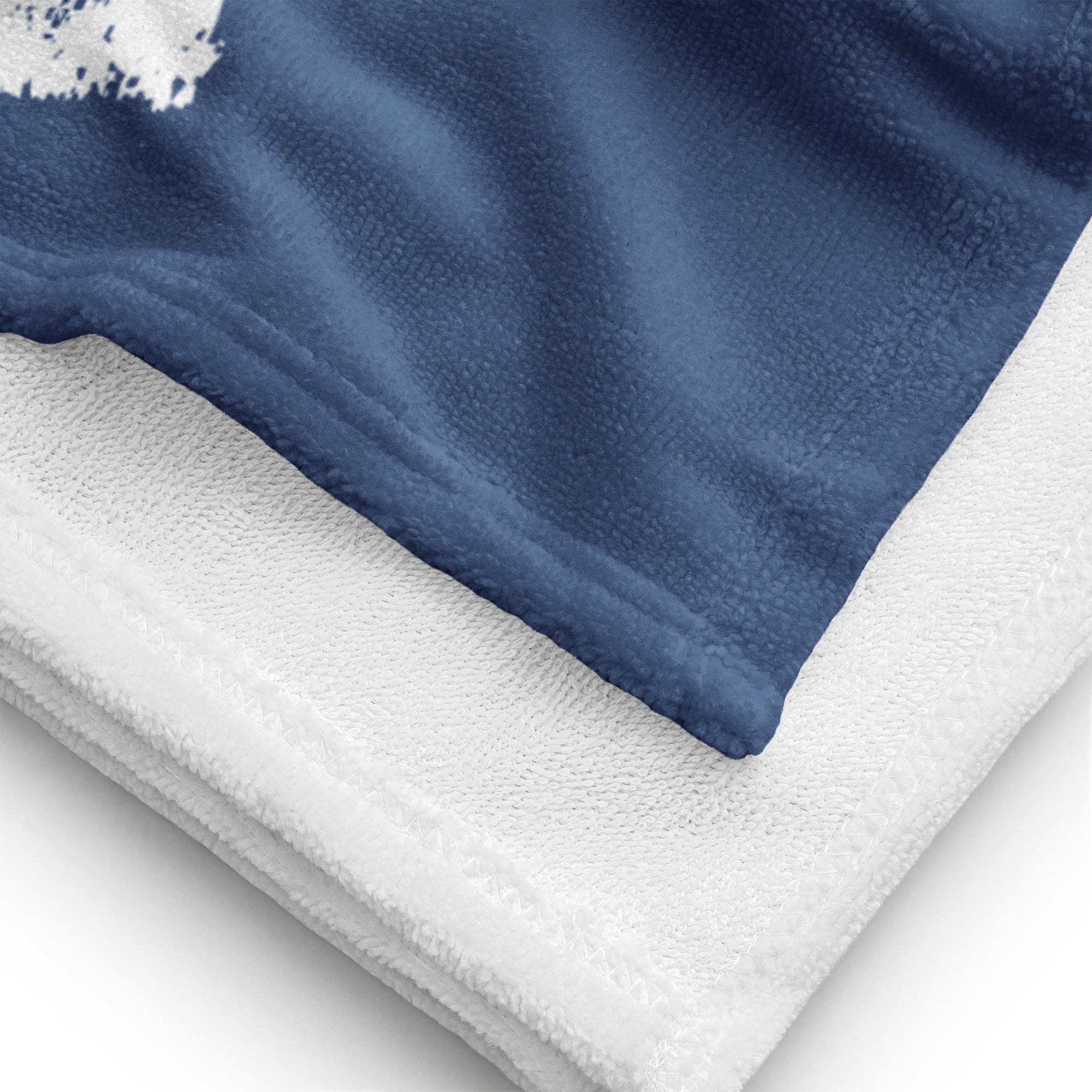 Nahaufnahme eines weißen und dunkelblauen Strandtuchs aus saugfähigem Material am Rand gefaltet