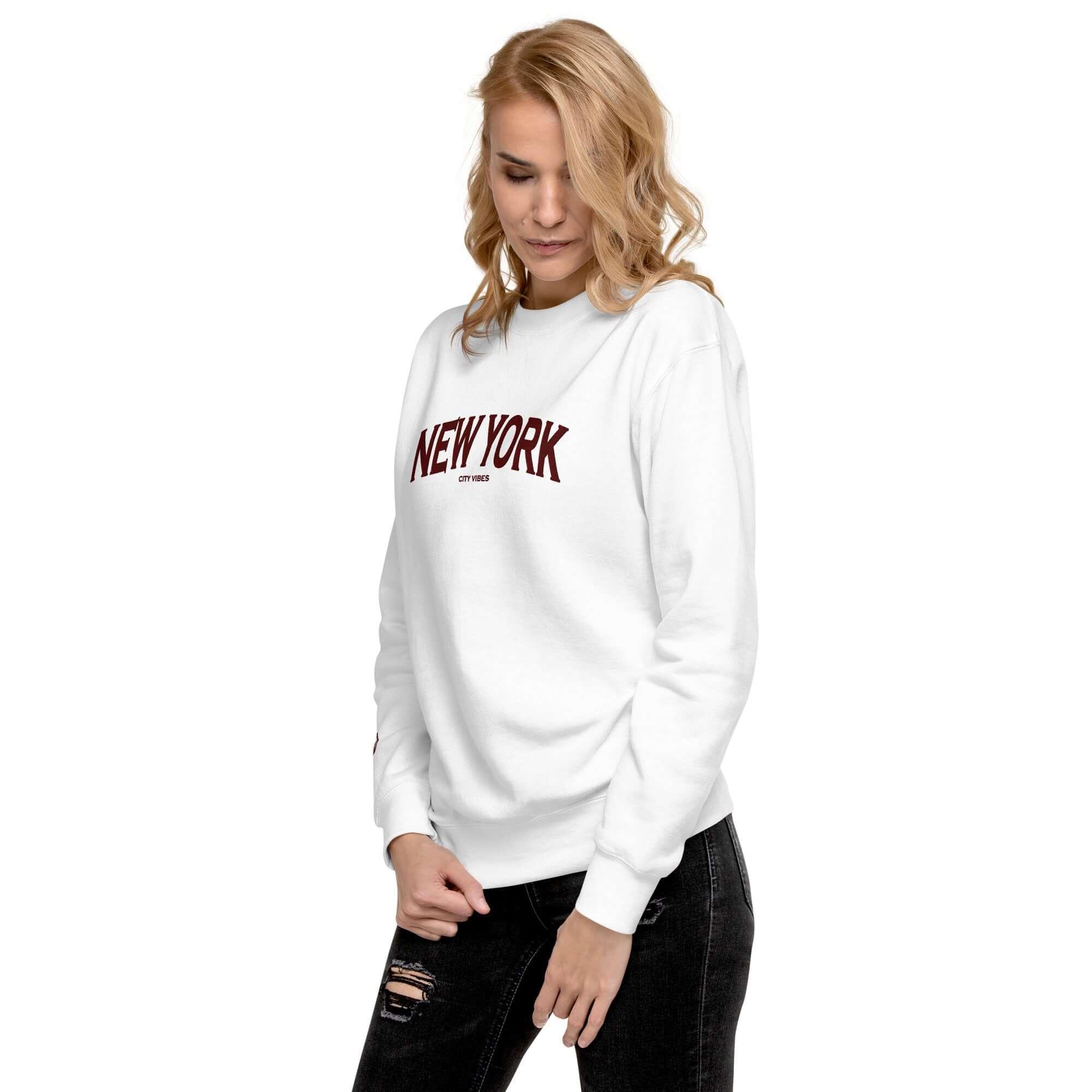 Frau trägt weißen Unisex-Sweatshirt mit New York Print, schwarze Jeans, modisch, Streetwear