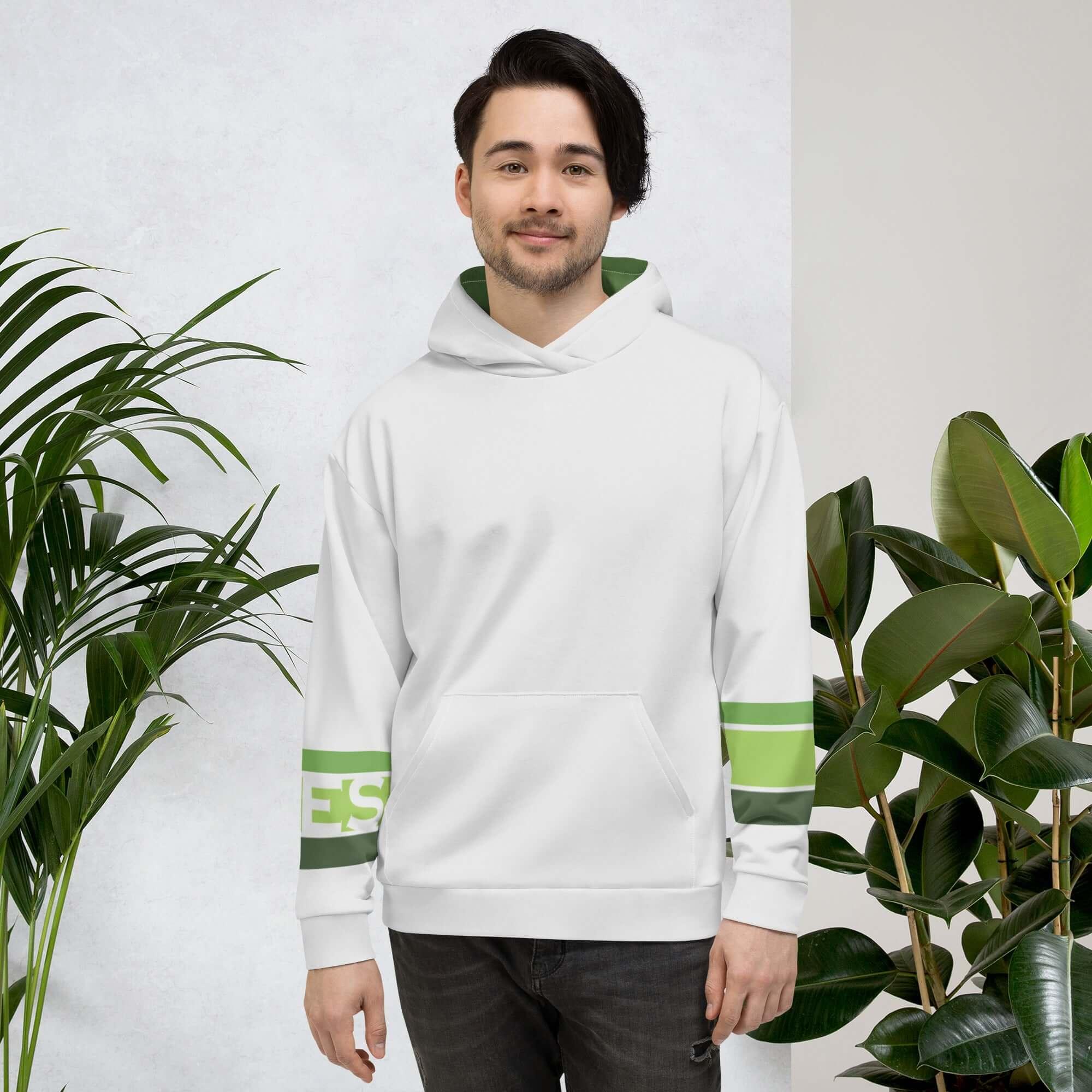 Mann trägt weißen VIBES Hoodie mit grünen Streifen, steht zwischen Zimmerpflanzen
