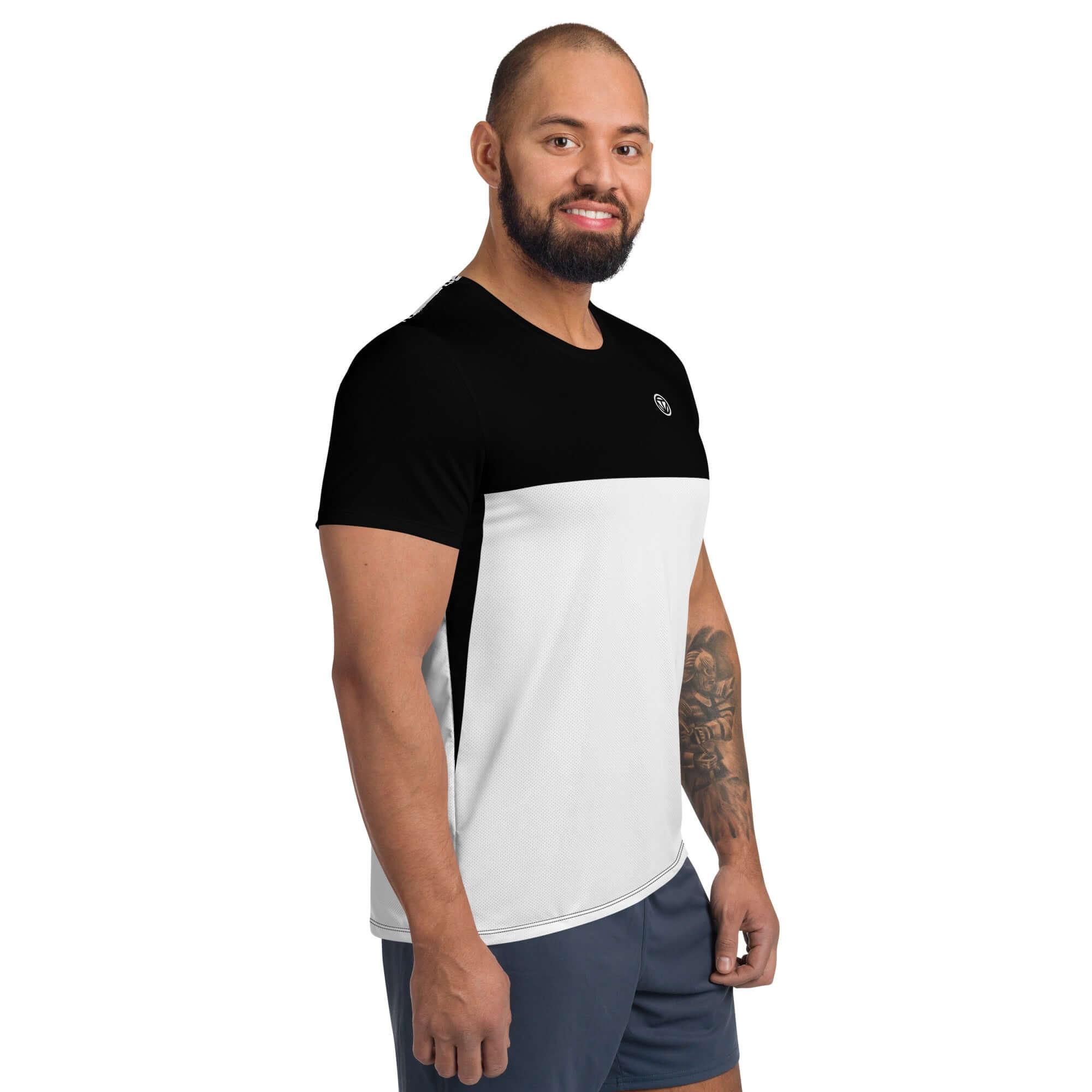 Mann mit kurzem Bart trägt schwarz-weißes Herren Sportshirt und Shorts vor weißem Hintergrund.