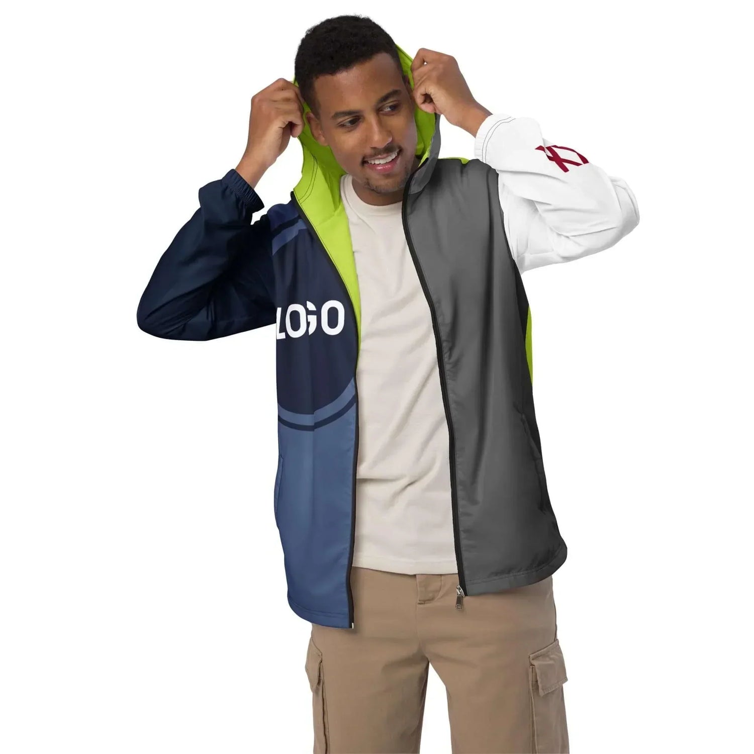 Mann trägt farbige Windjacke mit Kapuze und Logo, moderne Outdoor-Bekleidung auf Weiß.