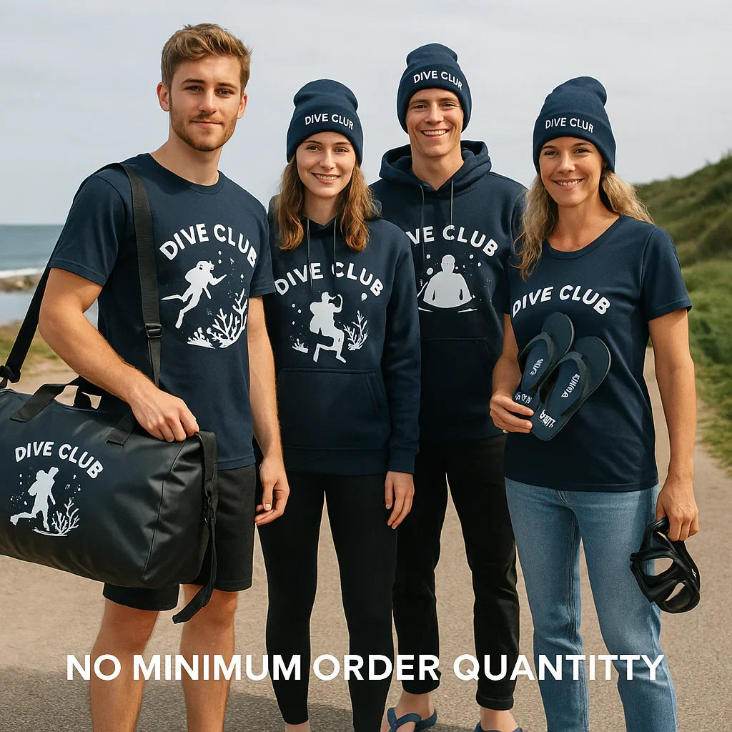 Vier junge Erwachsene im Dive Club Teamwear am Meer, tragen T-Shirts, Hoodies, Mützen.