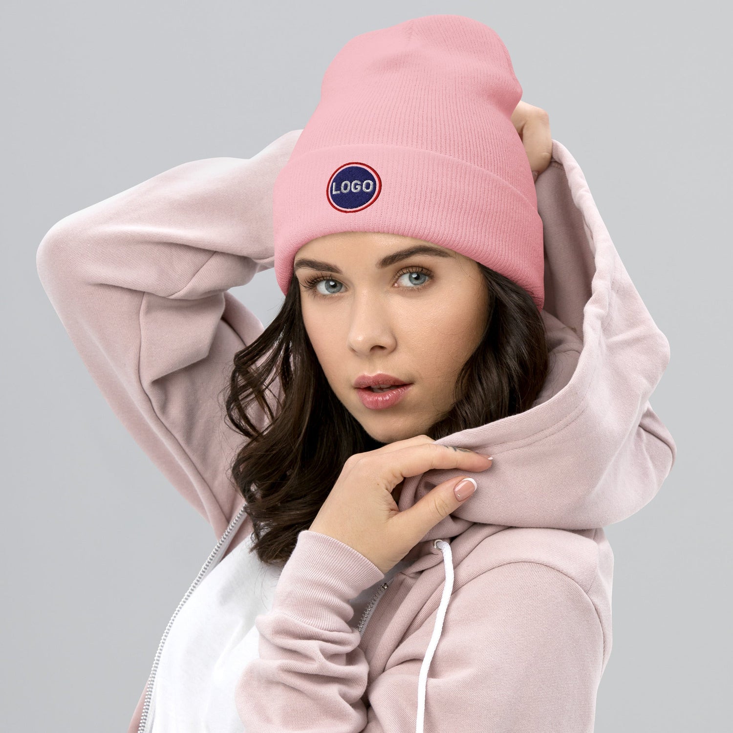 Frau mit babyrosa Mütze und Logo, rosa Hoodie, modisches Beanie-Accessoire