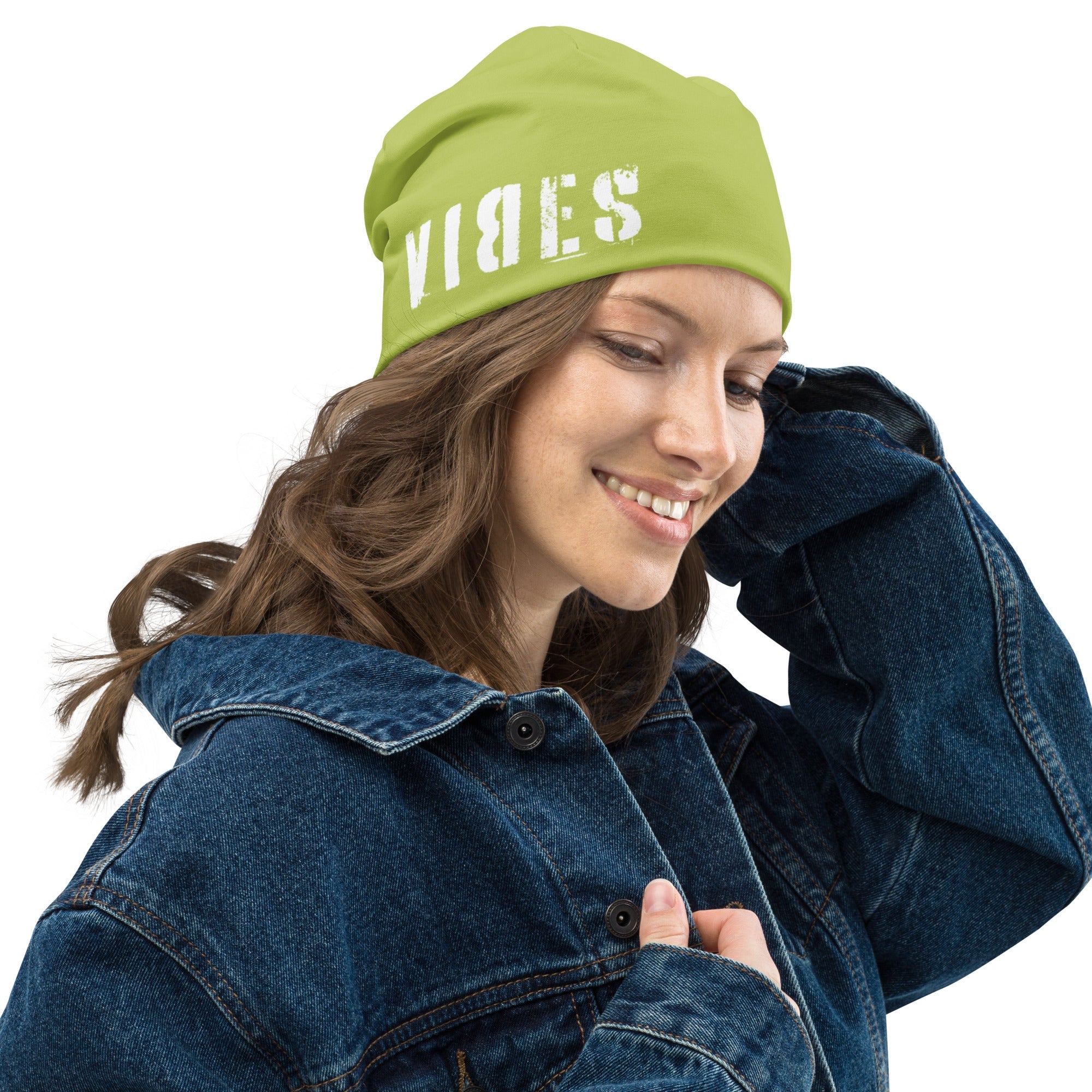 Frau mit gelber Beanie mit VIBES-Print und Jeansjacke auf weißem Hintergrund