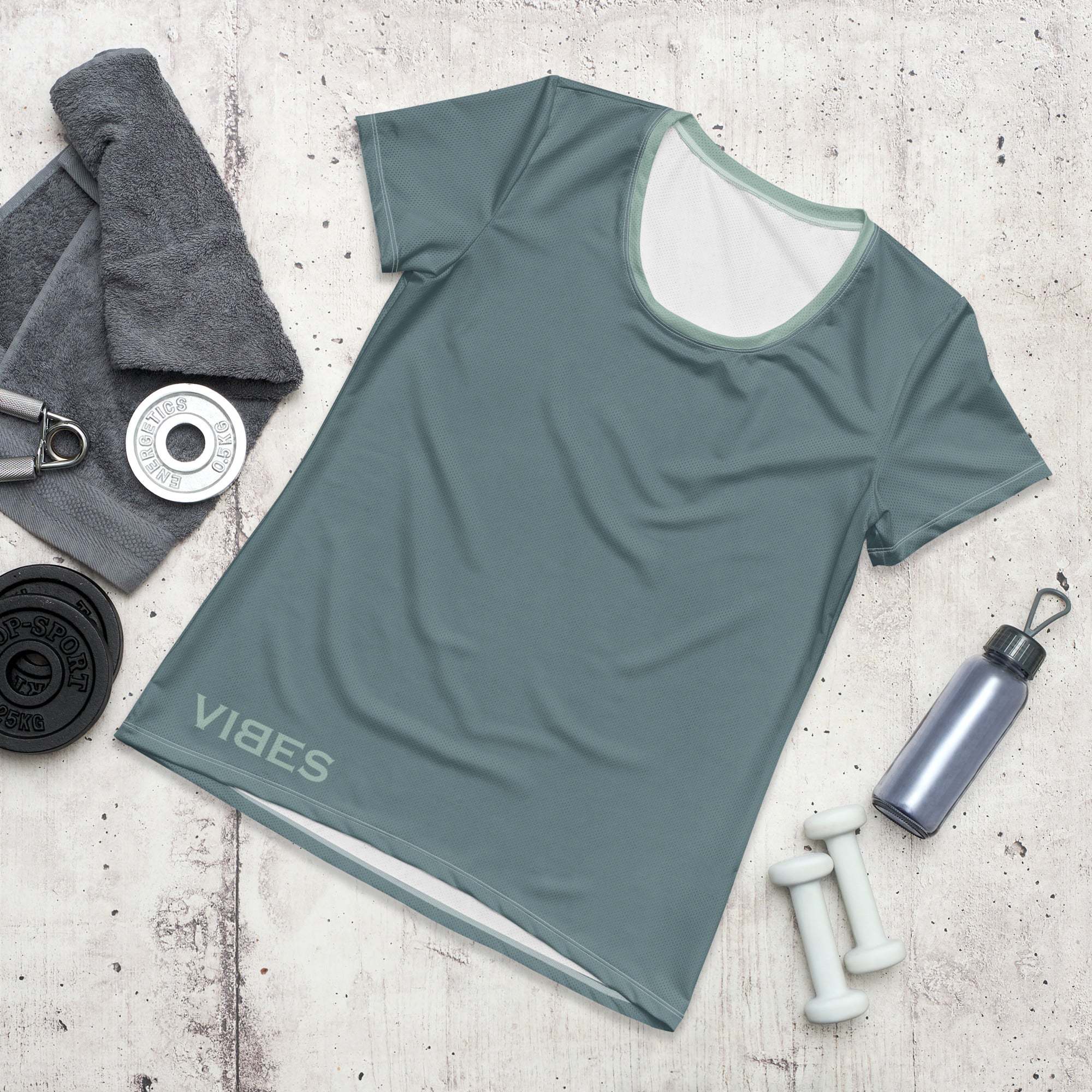 Graues Damen Sport T-Shirt mit VIBES Aufdruck auf Holzhintergrund, Fitness-Accessoires daneben